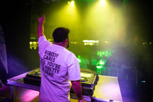 DJ Active steht vor dem Player und schaut auf die Menschenmenge